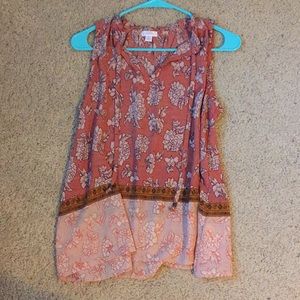 Coral/peach sleeveless blouse.